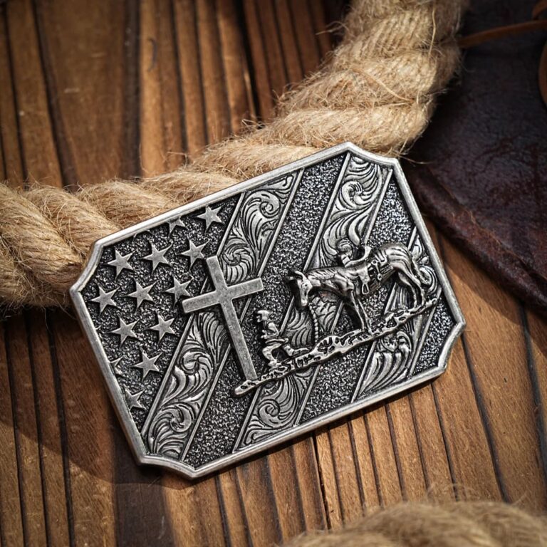 Bronze belt buckle featuring American flag, Christian cross, and praying cowboy with horse, embellished with scroll work designs.